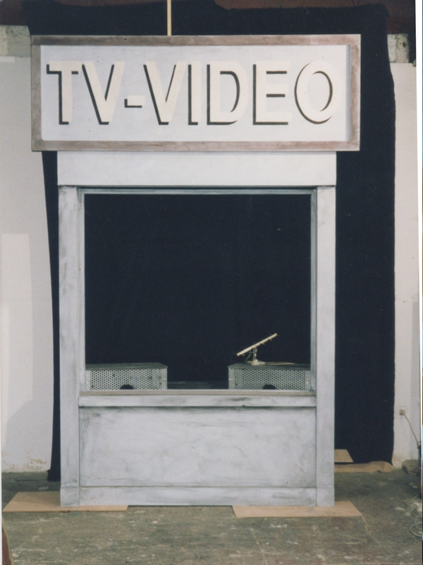 Ce décor de spectacle gris clair est une devanture de magasin.