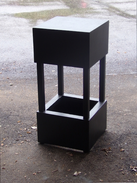 Ce tabouret, décor de spectacle, est un  assemblage de deux volumes noirs .